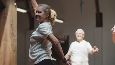 Medium-shot-of-happy-choreograph-showing-movements-in-ballroom