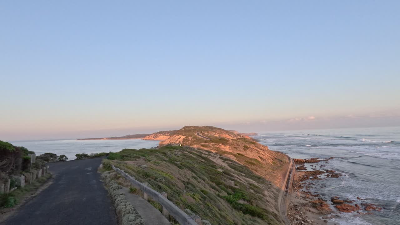 Blick bei Sonnenuntergang auf einen Küstenweg
