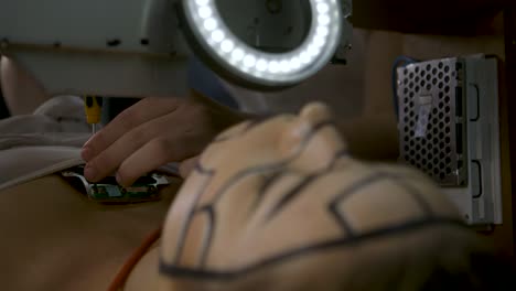 sci fi scene - young technician in a science fiction laboratory fixing a female droid