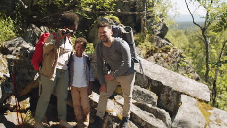 multiethnic family looking though binocular during hike