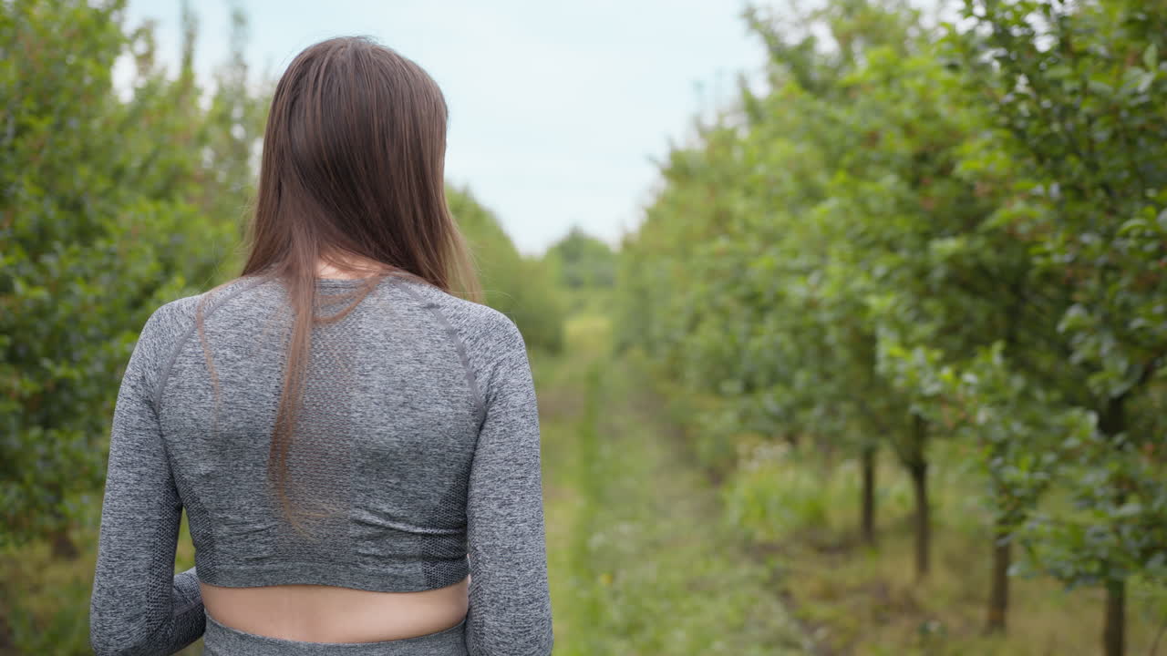 mujer tomando una foto en un huerto de manzanas