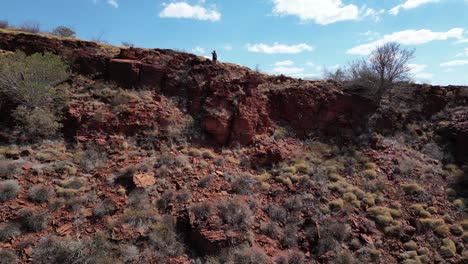 hombre de pie en el borde de la montaña rocosa en el desierto de australia occidental