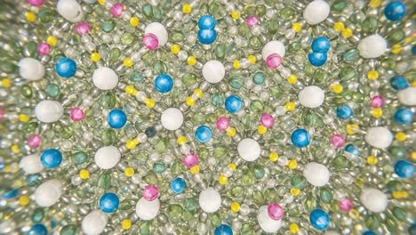 a captivating kaleidoscope of colorful beads: a magnified view featuring vibrant patterns of white, pink, blue, yellow, and green beads arranged harmoniously