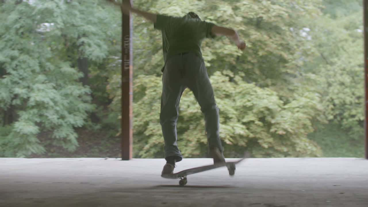 백인 소년이 폐허가 된 건물에서 스케이트보드를 타고 있습니다.