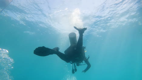 silhouette scuba diver sun beam shine rays underwater diver relaxing in blue ocean scenery 4k slow motion footage