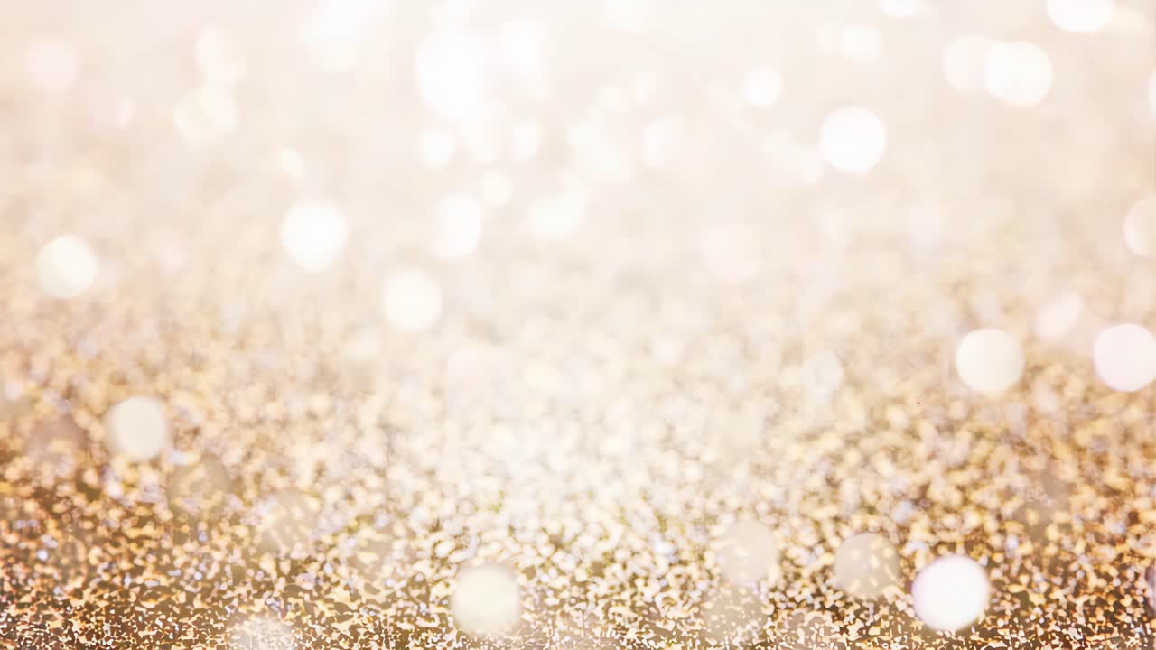 Una vista ravvicinata e sfocata di scintillanti glitter dorati, che crea un'atmosfera sognante e festosa
