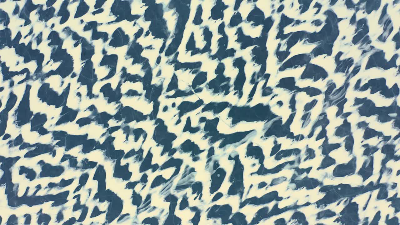 toma aérea de arriba hacia abajo volando de lado alto sobre los patrones de nieve barridos por el viento en un lago congelado