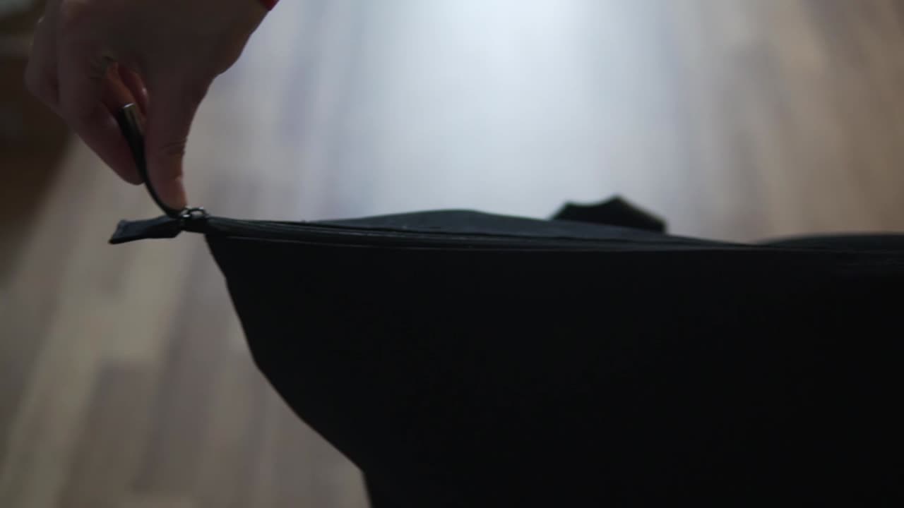 Kamera hareketi takip ederken, bir adamın su şişesini fermuarlı bir çantaya koyduğunu gösteren video