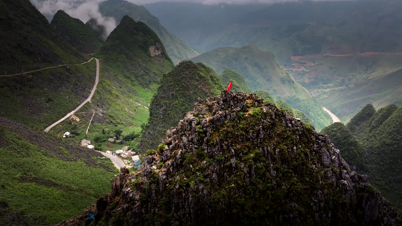 Aerial centered view of the Vietnam flag flying proudly over lush landscapes and rolling hills in northern Vietnam, scenic setting
