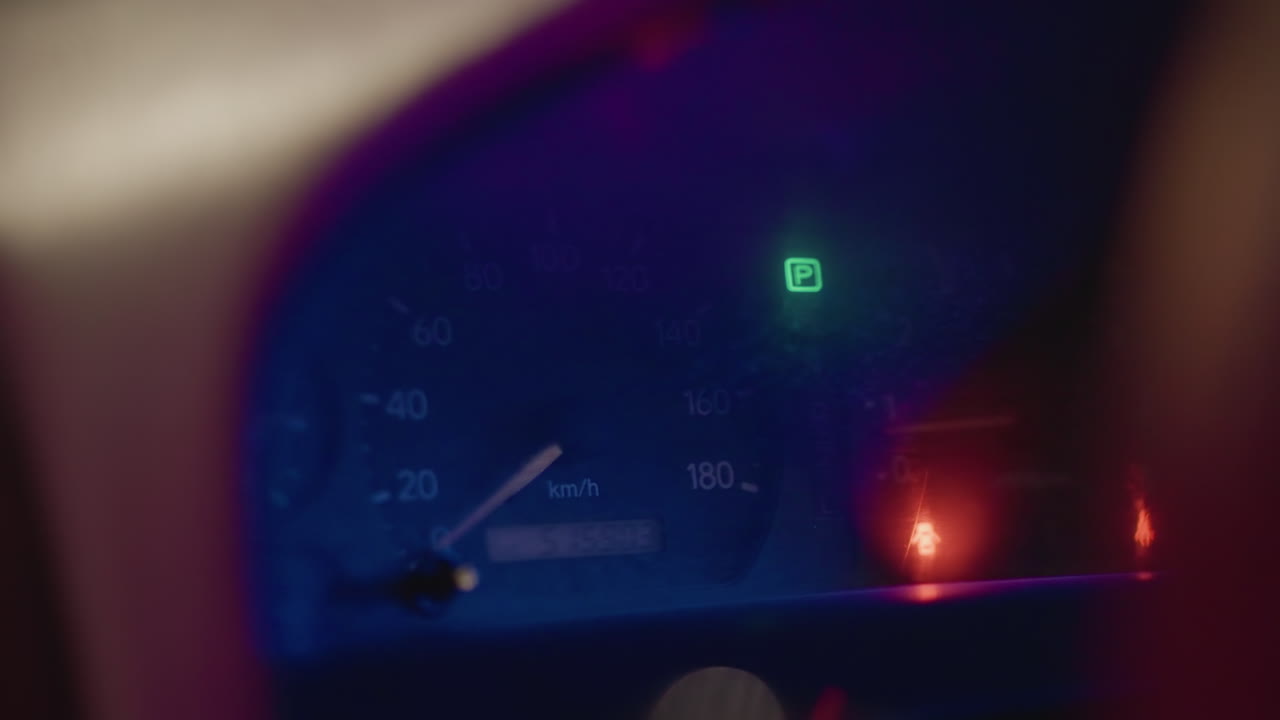 야간에 빛나는 계기판 클러스터, 선명한 속도계와 회전 속도계, 녹색 기어 표시등 활성화, 주행 거리계 숫자 표시, 은은한 보라색-파란색 내부 조명, 잔잔하고 반사적인 분위기, 고속도로 주행