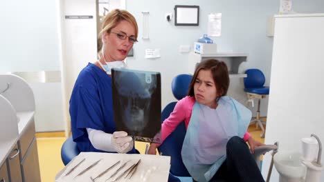 Pediatric-dentist-showing-x-ray-to-little-girl