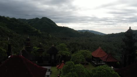 órbita aérea sobre un templo balinés rodeado de naturaleza, paisaje escénico en un día nublado, indonesia