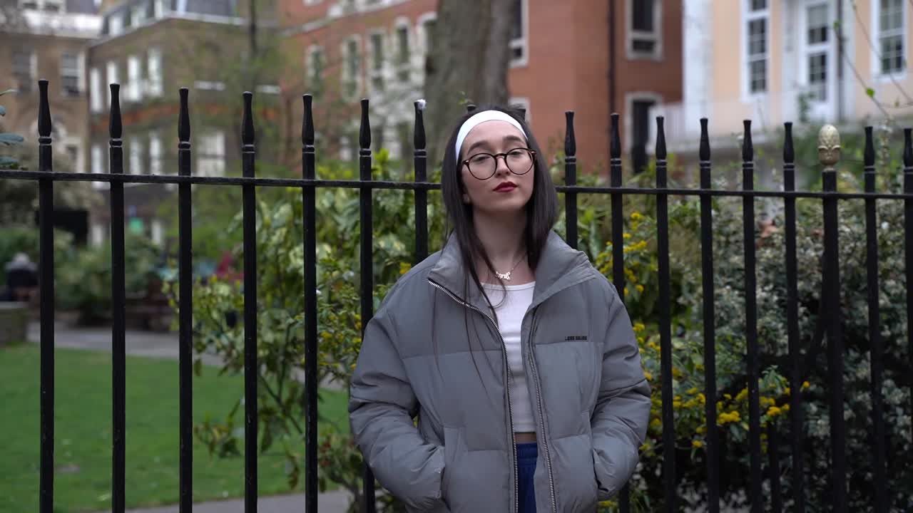 hermosa mujer joven con las manos en los bolsillos sonríe a la cámara, plano medio