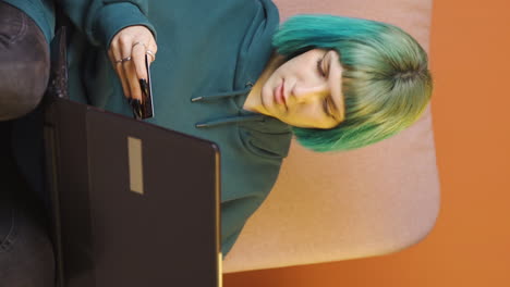 video vertical de una mujer joven comprando desde una computadora portátil.