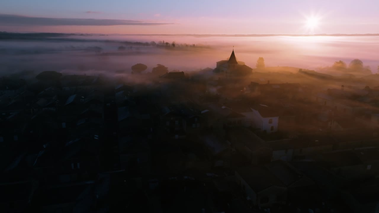 Misty Sunrise Above a Medieval Village, Drone view of village rooftops at dawn in the mist