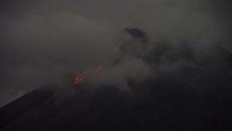 vista de la incandescencia del pico del monte merapi en yogyakarta, indonesia, acompañado de una espesa y densa niebla que lo cubre