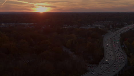 Aerial-of-highway-traffic-at-sunset-in-Autumn,-camera-slides-right