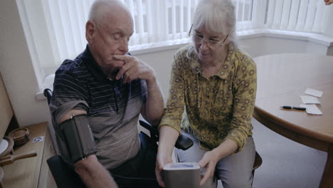 senior couple checking blood pressure at home