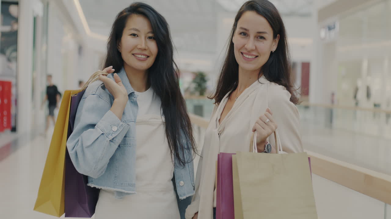 Two happy women shopping at the mall
