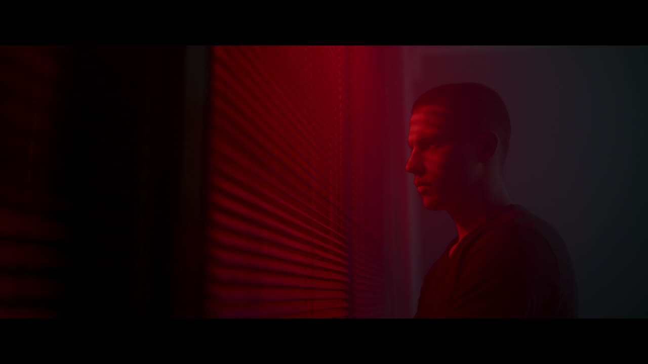 A young man looking at a red light window
