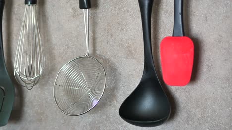 close-up of various kitchen utensils hanging on a wall