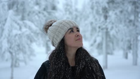 girl looking up around in snowy winter wonderland in lapland, finland, arctic circle