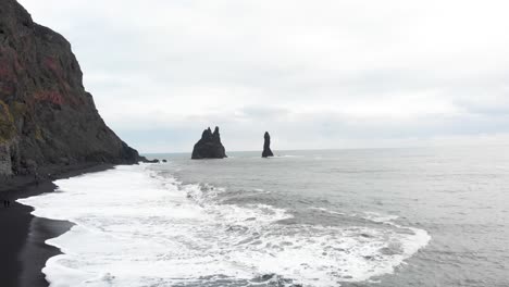 reynisdrangar basalt sea stack rock pillars in atlantic ocean, iceland