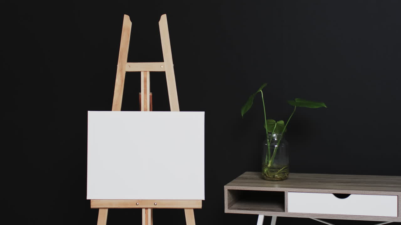 검은 바탕에 책상 위에 복사 공간과 식물과 함께 나무 easel에  ⁇  캔버스 표지판의 비디오