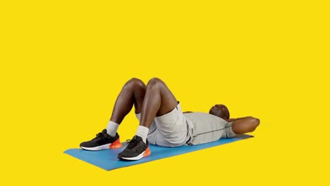sportive african man doing crunches in a mat