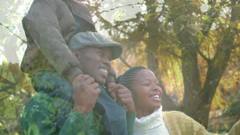 Animation-of-leaves-over-happy-african-american-couple-with-child