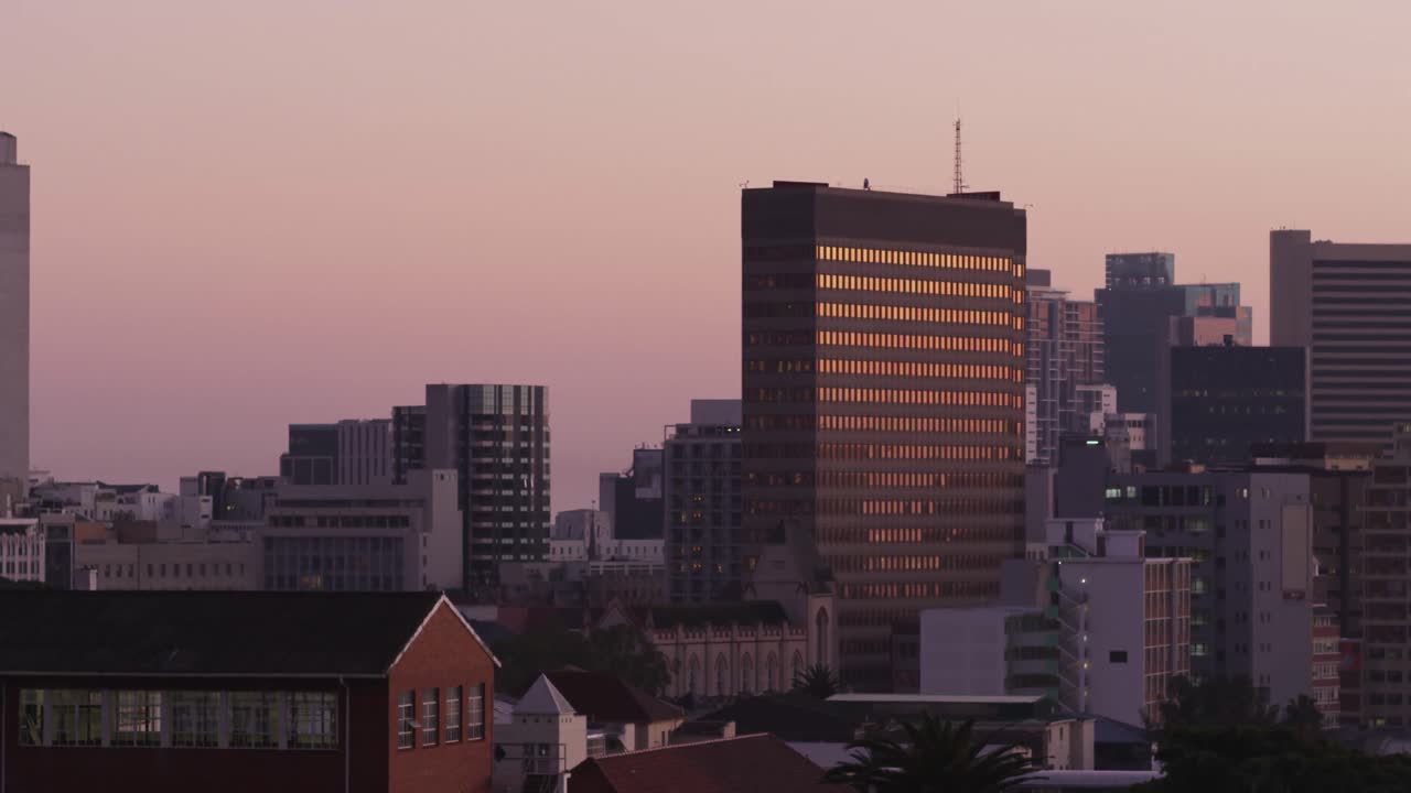 Vista general de paisaje urbano con múltiples edificios modernos y cielo despejado al atardecer
