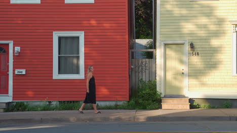 close shot of colourful homes with woman walking in front of in the morning in halifax, nova scotia