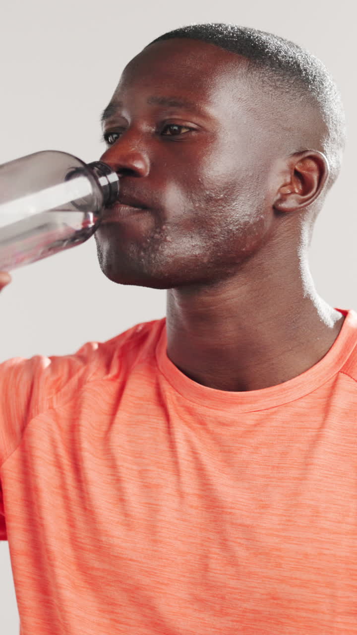 Sweaty Black Man Drinking Water from Bottle After Workout