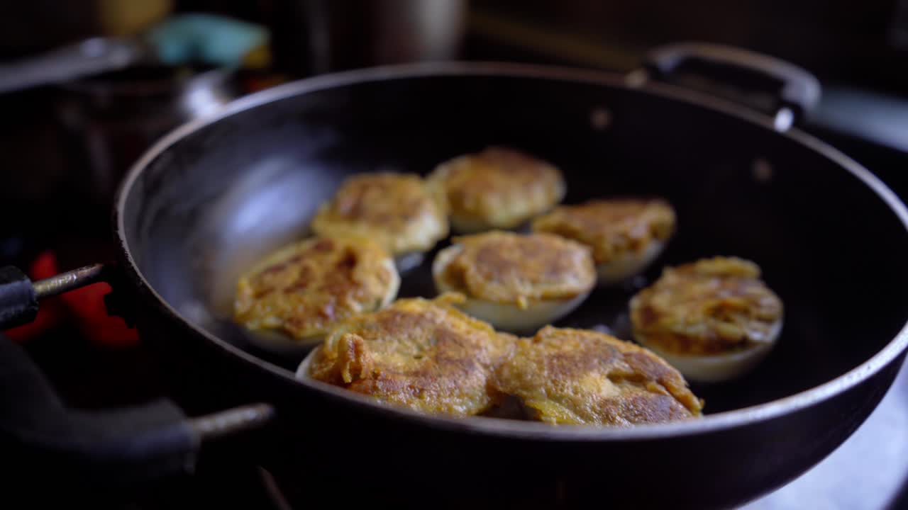 a cinematic shot pan-frying boiled egg in oil homemade Deviled egg is also known as stuffed eggs, Russian eggs, or dressed eggs