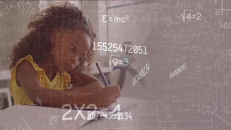 animation of maths calculations and data over biracial schoolgirl concentrating at desk in class