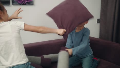 kids fight with pillows at home. children fighting with fun at home