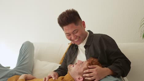 happy lgbtq+ couple relaxing on couch