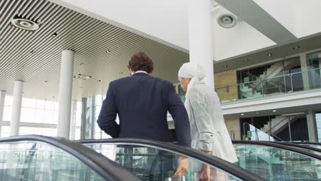 Young-business-people-on-an-escalator-in-a-modern-building