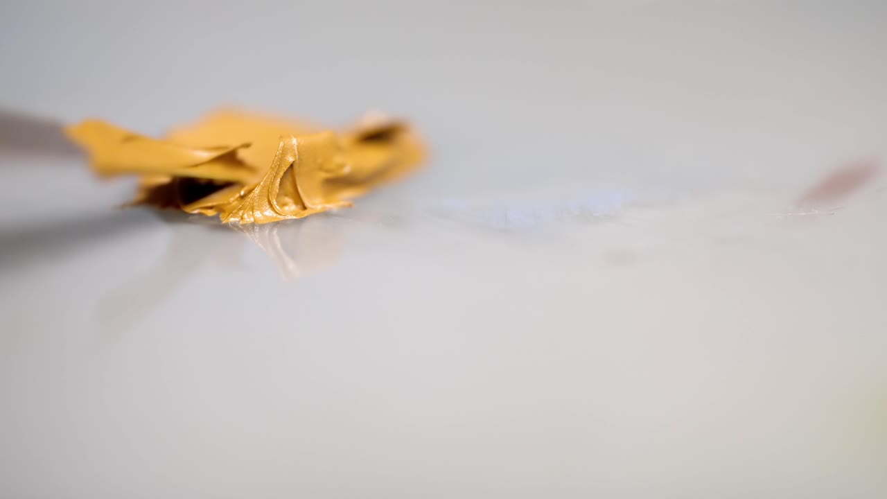 예술가 들 은  ⁇ 싱 테이블 에 노란색 기름 페인트 를 뿌리는 팔레트 칼 을 사용 한다