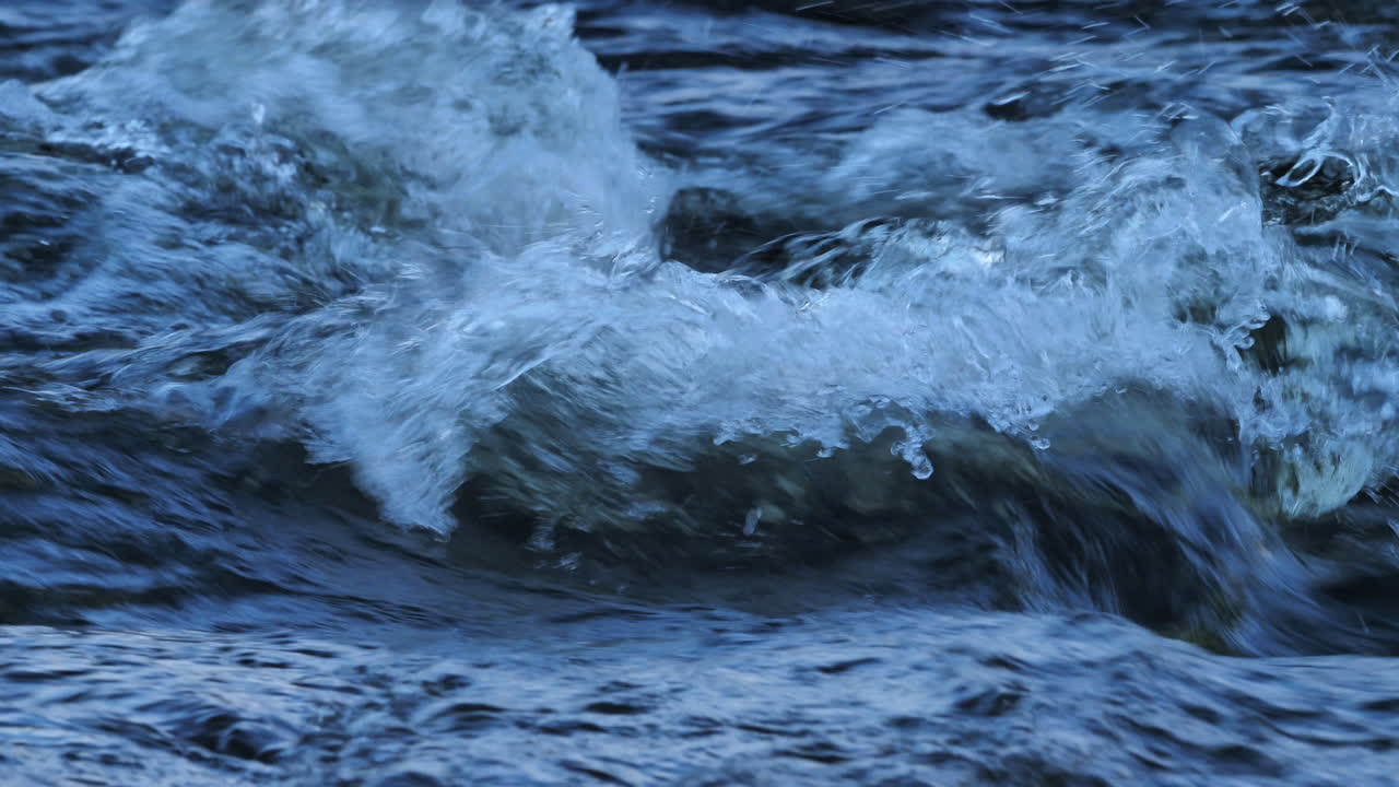Detailed slow-mo footage of mesmirising rapids, with water flowing and bubbling in a stream in Northumberland, England