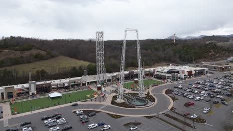 aerial rotating shot of a bungee jump in a shopping plaza in piegon forge, tn.