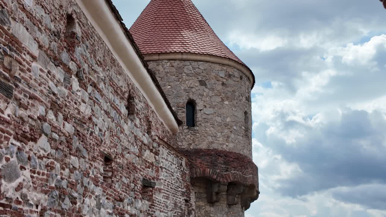 Corvin Castle featuring a smooth upward pan revealing the medieval stone tower and detailed Gothic architecture