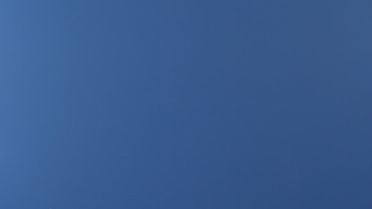 se ve una rebanada de pizza volando en el aire frente a una pantalla azul