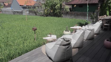 asientos frente a campos de arroz, bolsas de frijoles y mesa de madera en forma de corazón en canggu, bali.