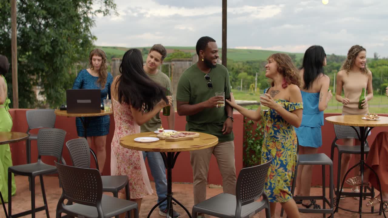 Friends enjoying an outdoor rooftop party with drinks and conversation