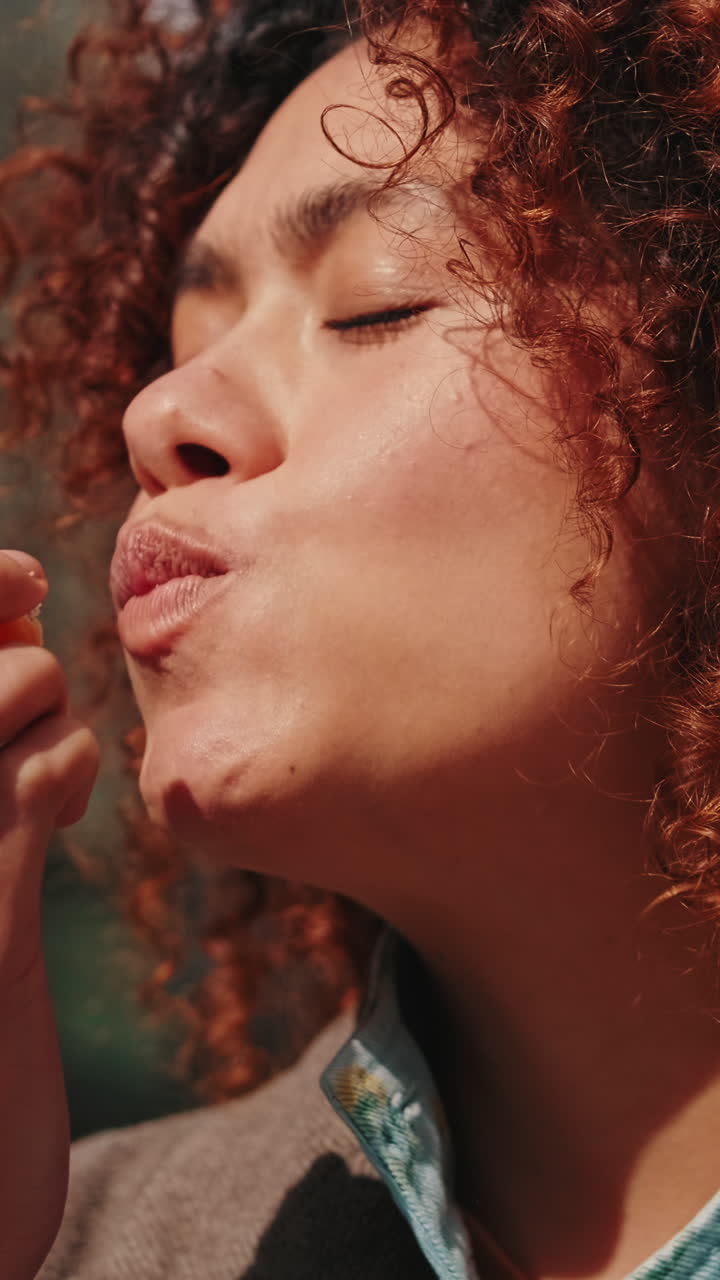 Young Woman Eating a Mandarin Orange Outdoors