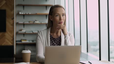 focused attractive blonde business woman working on computer in office.