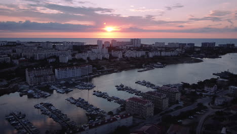 sunset over coastal city with marina