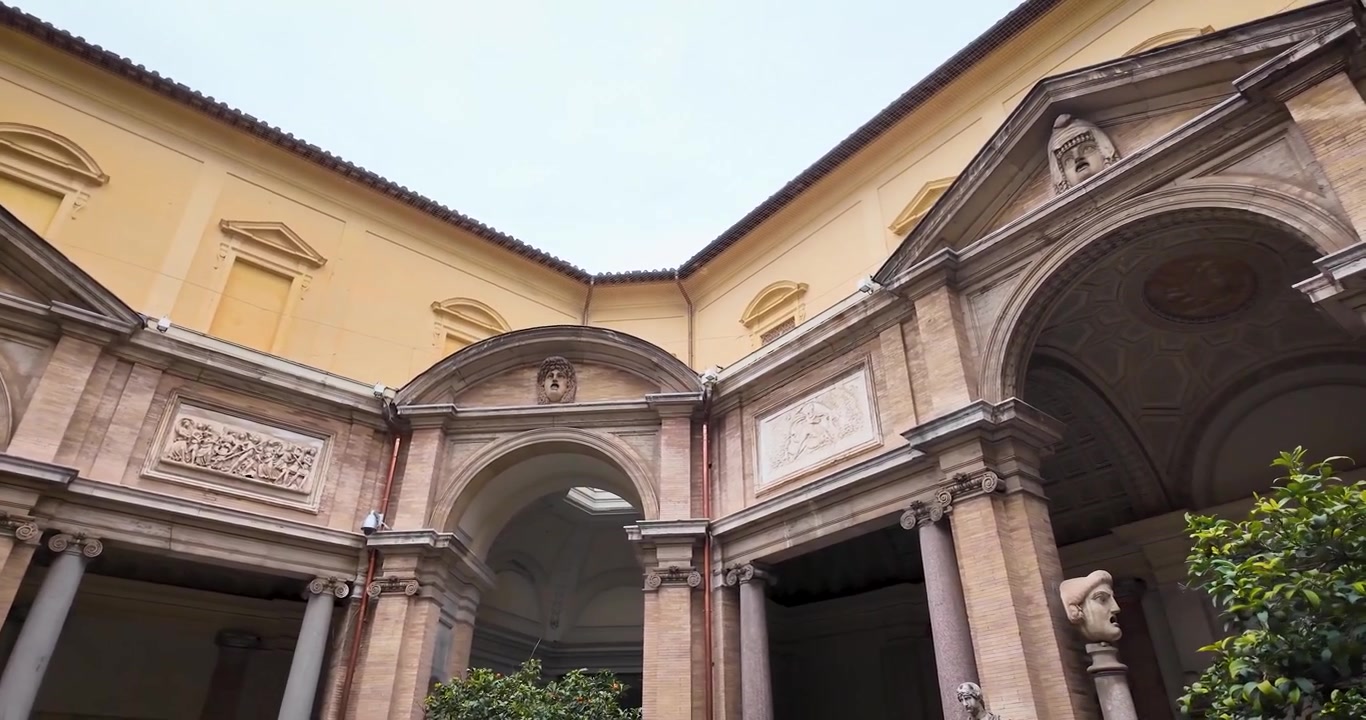 Veduta architettonica della storica Corte Ottagonale nei Musei Vaticani, caratterizzata da arcate rinascimentali, rilievi in pietra e l'ex Cortile delle Statue