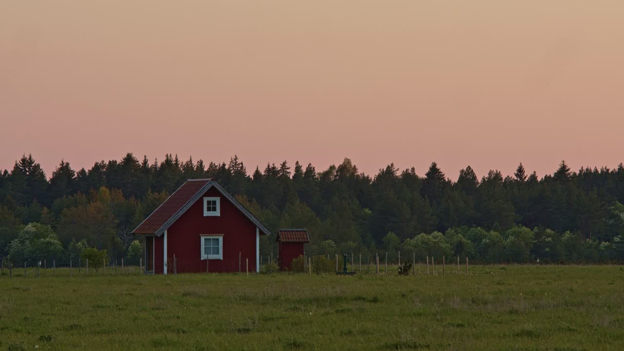 Beautiful cottage with forest in background during summer solstice sunset